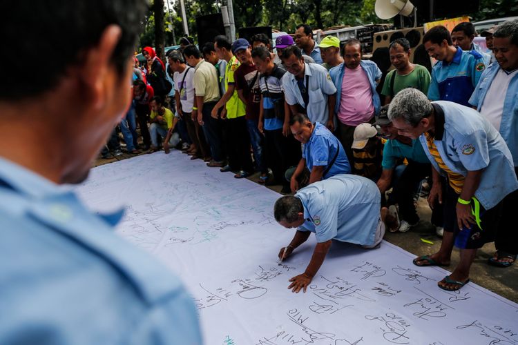 Para pengemudi angkutan umum berbagai jurusan Tanah Abang melakukan aksi unjuk rasa di depan Balai Kota DKI Jakarta, Senin (22/1/2018). Mereka tidak terima dengan kebijakan Pemprov DKI Jakarta yang menutup ruas jalan demi pedagang kaki lima.