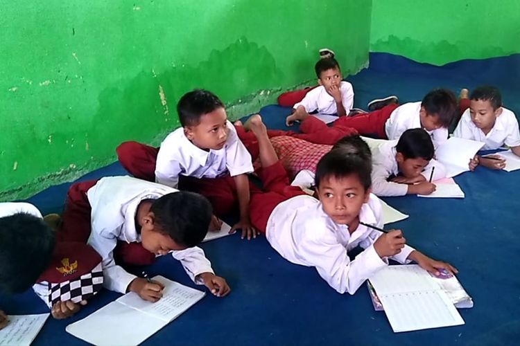 Siswa SDN 3 Pasirkupa, Kecamatan Kalanganyar, Kabupaten Lebak, Banten, belajar lesehan di lantai di gedung madrasah yang dipinjam lantaran kekurangan fasilitas kelas, Rabu (30/10/2019)