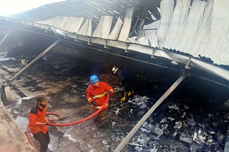 Petugas memadamkan api yang membakar gudang milik PT Hartono Istana Teknologi yang terletak di Kecamatan Sayung , Kabupaten Demak  Jateng