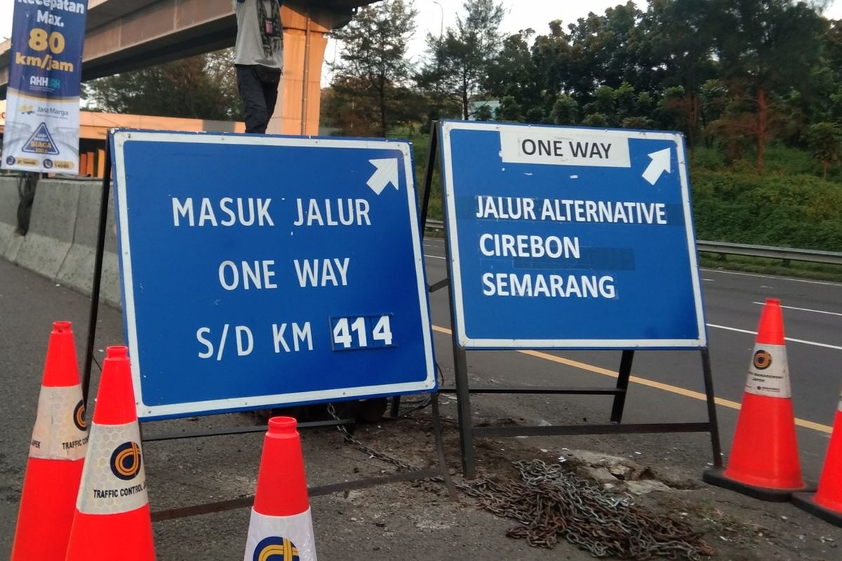 Petugas tengah mengarahkan kendaraan masuk lajur kanna pada penerapan one way di kilometer 47 tol Jakarta-Cikampek, Rabu (28/4/2022).