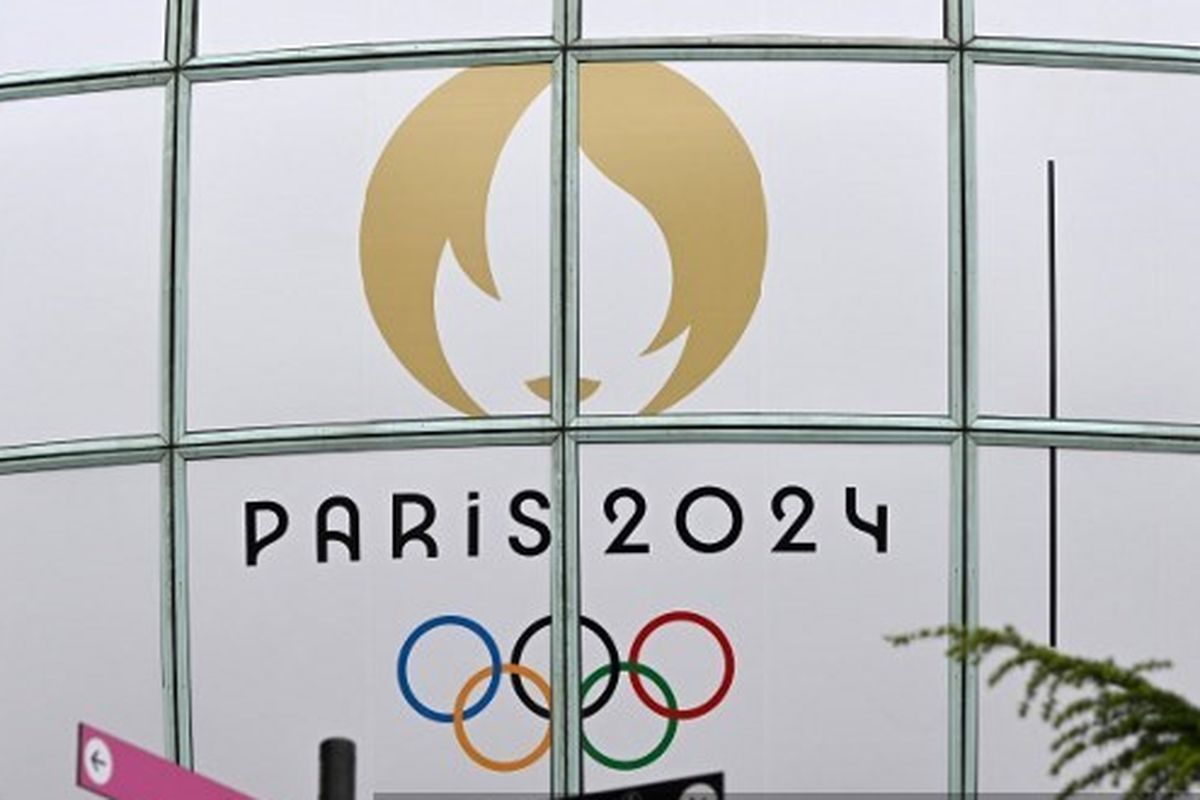 Dua orang berjalan melewati logo Olimpiade 2024 Paris di La Defense pada 22 Juli 2024. Artikel ini berisi jadwal siaran langsung Olimpiade 2024.