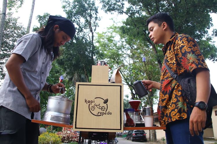 Asep (kiri) dan Ade (kanan) saat membuat Kopi Sepeda, pesanan penikmat kopi di depan Taman Cadika, Medan. 