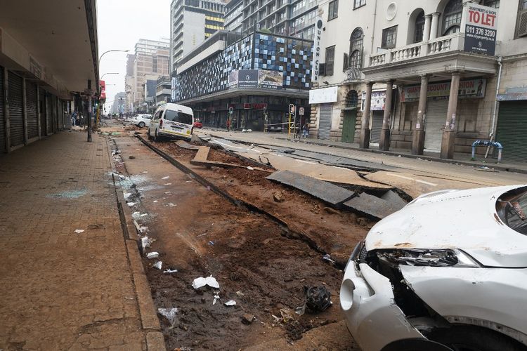 Pemandangan jalan yang rusak di Johannesburg pada tanggal 20 Juli 2023, setelah ledakan misterius terjadi pada jam-jam sibuk pada tanggal 19 Juli 2023. Sesosok mayat pria ditemukan di Johannesburg pada Kamis dini hari setelah sebuah ledakan yang tidak dapat dijelaskan mengoyak pusat kota, merobek jalan utama dan melukai 41 orang, kata para pejabat. 