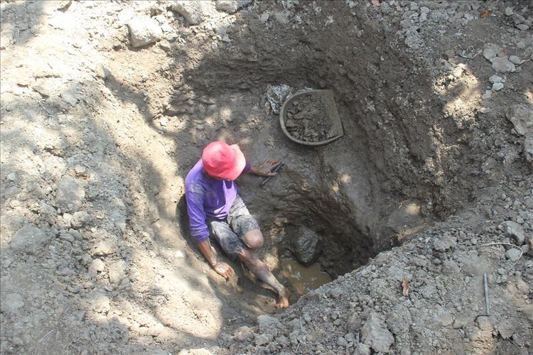 Seorang warga di Kp. Cisalak Hilir, Desa Cisalak, Kecamatan Cibeber, Kabupaten Cianjur, Jawa Barat terpaksa menggali tanah di dalam kolam yang telah mengering untuk mencari sumber air baru menyusul bencana kekeringan yang tengah melanda dan mengakibatkan krisis air bersih, Selasa (13/8/2019). 