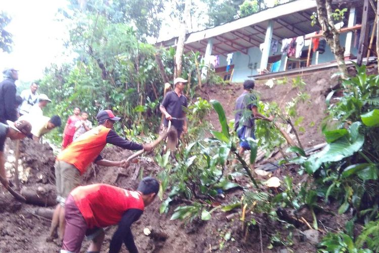 BERSIHKAN-Tim BPBD Ponorogo bersama warga membersihkan material tanah longsor yang menutup ruas jalan di Desa Talun, Kecamatan Ngebel, Kabupaten Ponorogo, Minggu ( 5 / 3 / 2017) .