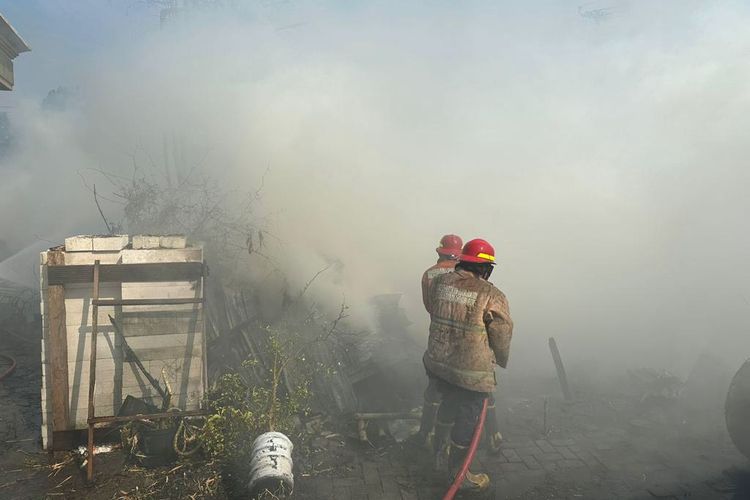 Petugas Damkarla Gresik saat melakukan pembasahan pada area gudang kayu yang terbakar di Prambangan, Kecamatan Kebomas, Gresik, Jawa Timur, Jumat (20/10/2023).