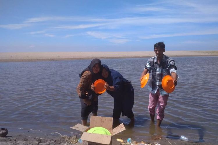 Wisatawan mencuci piring usai menikmati makanan yang dibawa dari rumah di bibir Pantai Rancong, Desa Rancong, Kecamatan Muara Satu, Kota Lhokseumawe, Kamis (2/5/2019) 