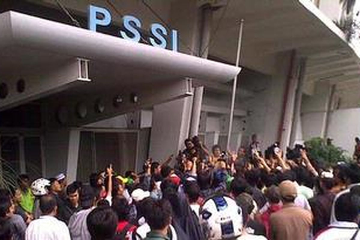 Suporter tim nasional Indonesia menurunkan bendera PSSI di depan kantor PSSI di kompleks Stadion Gelora Bung Karno, Senayan, Jakarta Pusat, Sabtu (18/12/2010). Mereka kecewa karena panitia tidakj membuka loket penjualan tiket pada hari tersebut.