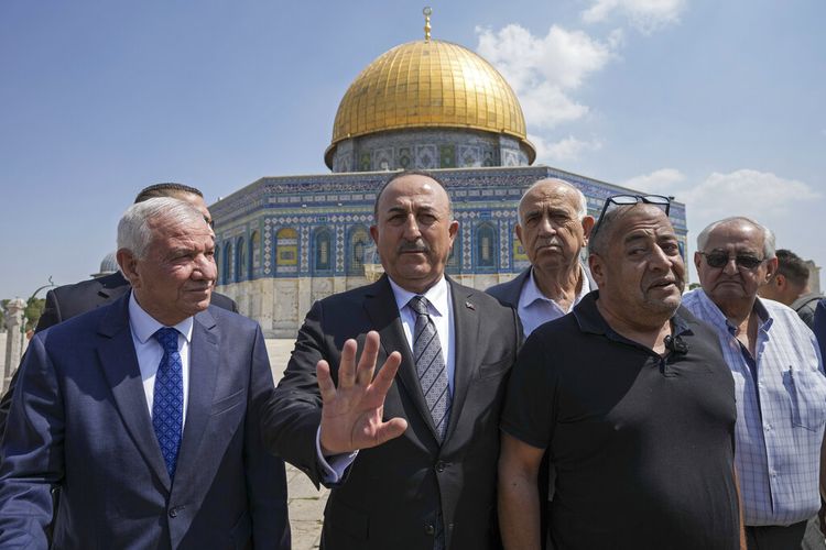 Menteri Luar Negeri Turki Mevlut Cavusoglu, tengah, dan Sheikh Azzam Al-Khatib, kiri, Direktur Departemen Wakaf Yerusalem, bersama pejabat Palestina lainnya mengunjungi kompleks Masjid Al Aqsa di Kota Tua Yerusalem, Rabu, 25 Mei 2022. 
