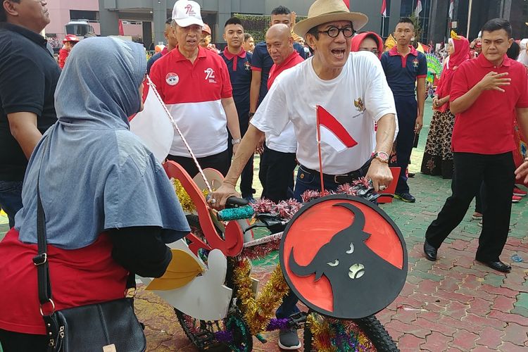 Menteri Hukum dan HAM Yasonna H Laoly menenteng sepeda dari Presiden Jokowi, dalam acara lomba rias sepeda yang digelar Kemenkumham, Sabtu (19/8/2017).