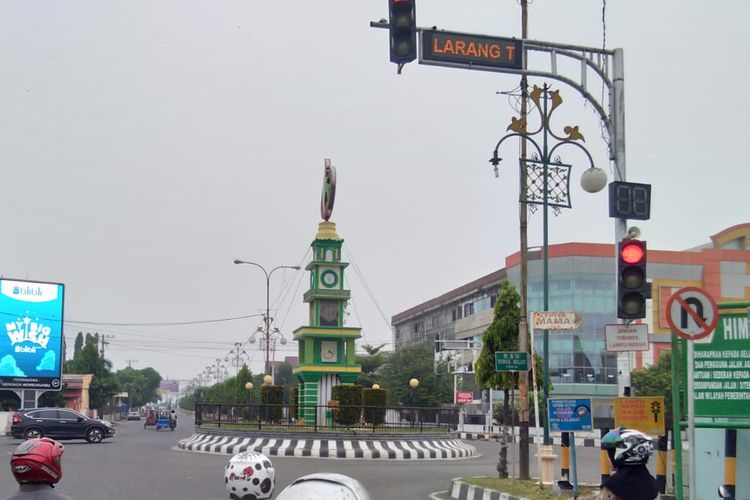 Pengguna jalan berhenti di lampu merah Simpang Tugu Bank Aceh yang diselimuti kabut asap di Jalan Merdeka, Kota Lhokseumawe, Senin (23/9/2019)