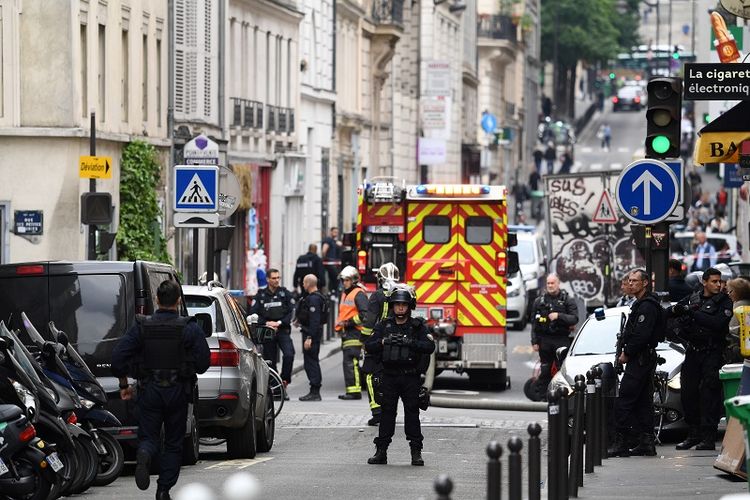 Petugas kepolisian Perancis berjaga di ruas jalan tak jauh dari lokasi penyanderaan di pusat kota Paris, Selasa (12/6/2018).