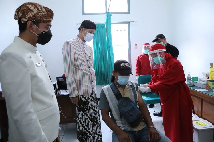 Gubernur Jawa Tengah Ganjar Pranowo (tengah memakai masker warna putih) didamping Wali Kota Surakarta Gibran Rakabuming Raka (memakai masker warna hitam) secara langsung meninjau proses vaksinasi, di Pasar Legi, Surakarta, Jawa Tengah, Kamis (4/3/2021). 