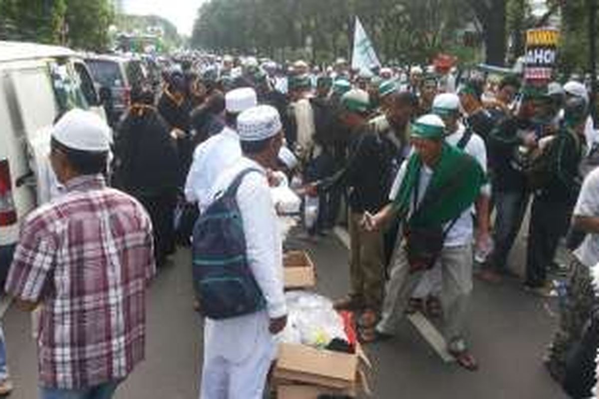 Sejumlah relawan membagi-bagikan makanan dan minuman  untuk para peserta kegiatan doa dan dzikir bersama yang diadakan di Lapangan Monas, Jumat (2/12/2016) pagi. 