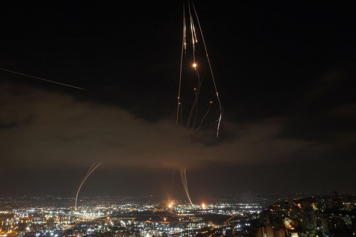 Sistem pertahanan udara Israel diaktifkan untuk mencegat rudal Iran di atas kota Haifa di tengah rentetan serangan roket Iran pada sENIN (16/6/2025).