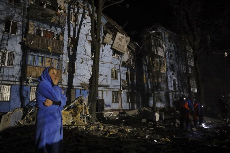 Seorang warga berdiri di depan tempat tinggalnya yang rusak setelah Rusia melancarkan seranagn rudal di Zaporizhzhia, Ukraina, Kamis (2/3/2023).