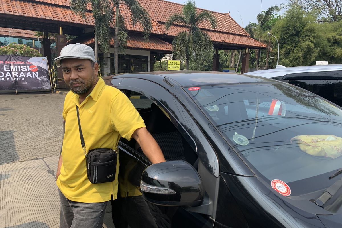 Sopir taksi online Ahmad Isa (51) melakukan uji emisi kendaraan secara gratis di Jalan Inspeksi Tambun Barat, Kecamatan Tambun Selatan, Kabupaten Bekasi, Rabu (20/9/2023).