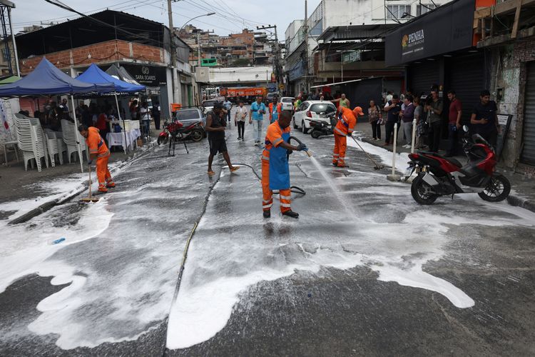 Para pekerja membersihkan jalan sehari setelah operasi penggerebekan narkoba perdagangan di permukiman kumuh Penha, Rio de Janeiro, Brasil, Rabu (29/10/2025).