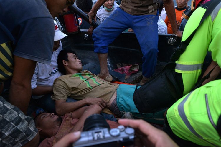 Petugas merawat salah seorang penambang yang selamat dari lokasi Pertambangan Emas Tanpa Izin (PETI) Desa Bakan, Kecamatan Lolayan, Kabupaten Bolaang Mongondouw, Sulawesi Utara, Rabu (27/2/2019). Sebanyak 23 orang penambang tertimbun longsor, 19 orang di antaranya selamat dan 4 orang tewas.