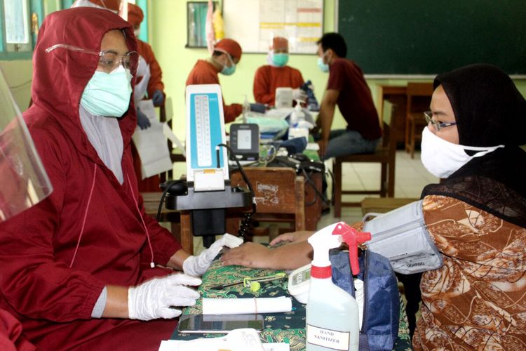 Warga Kelurahan Ngadirejo, Kecamatan Kepanjenkidul, Kota Blitar menjalani pemeriksaan kesehatan sebelum mendapatkan suntikan vaksin, Selasa (24/8/2021)