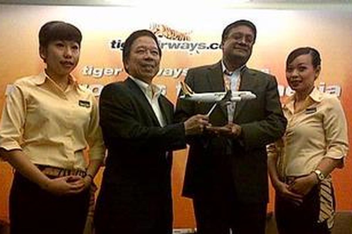 Managing Director Tiger Airways, Ho Yuen Sang bersama Commercial Director Tiger Airways, Kaneswaran Avili diapit dua awak kabin dalam jumpa pers peluncuran rute penerbangan Tiger Airways ke Bandung dan Yogyakarta di Changi Village Hotel, Netheravon RD, Singapura, Senin (6/5/2013).