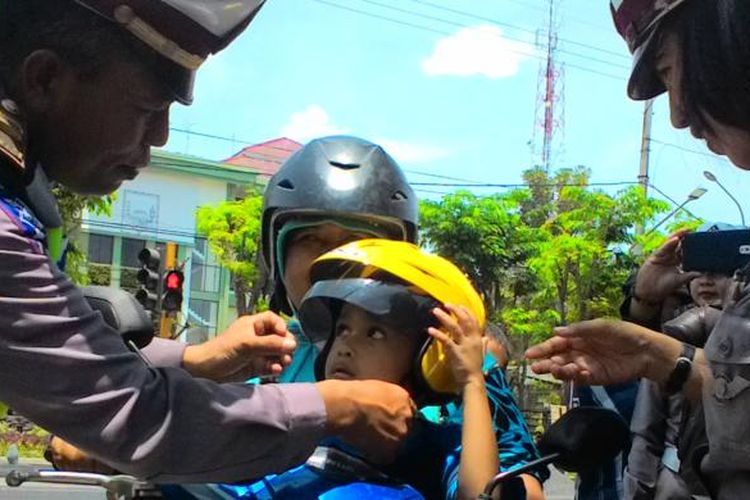 Seorang anak mendapatkan helm gratis dari Polisi dalam operasi simpatik di Kabupaten Probolinggo. 