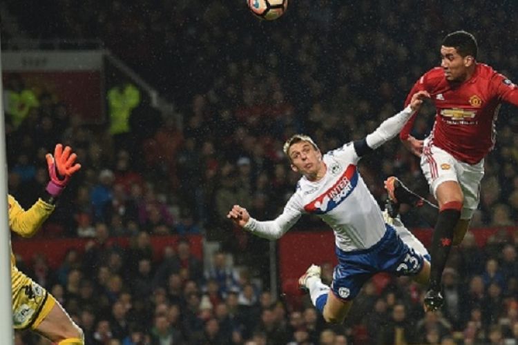Bek Manchester United, Chris Smalling, mencetak gol via sundulan saat menghadapi Wigan Athletic dalam laga Piala FA di Old Trafford, Minggu (29/1/2017). 