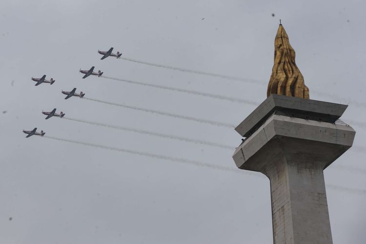 Atraksi udara  tim aerobatik Jupiter dari TNI Angkatan Udara saat perayaan HUT ke-77 TNI di atas Monumen Nasional, Jakarta, Rabu (5/10/2022).