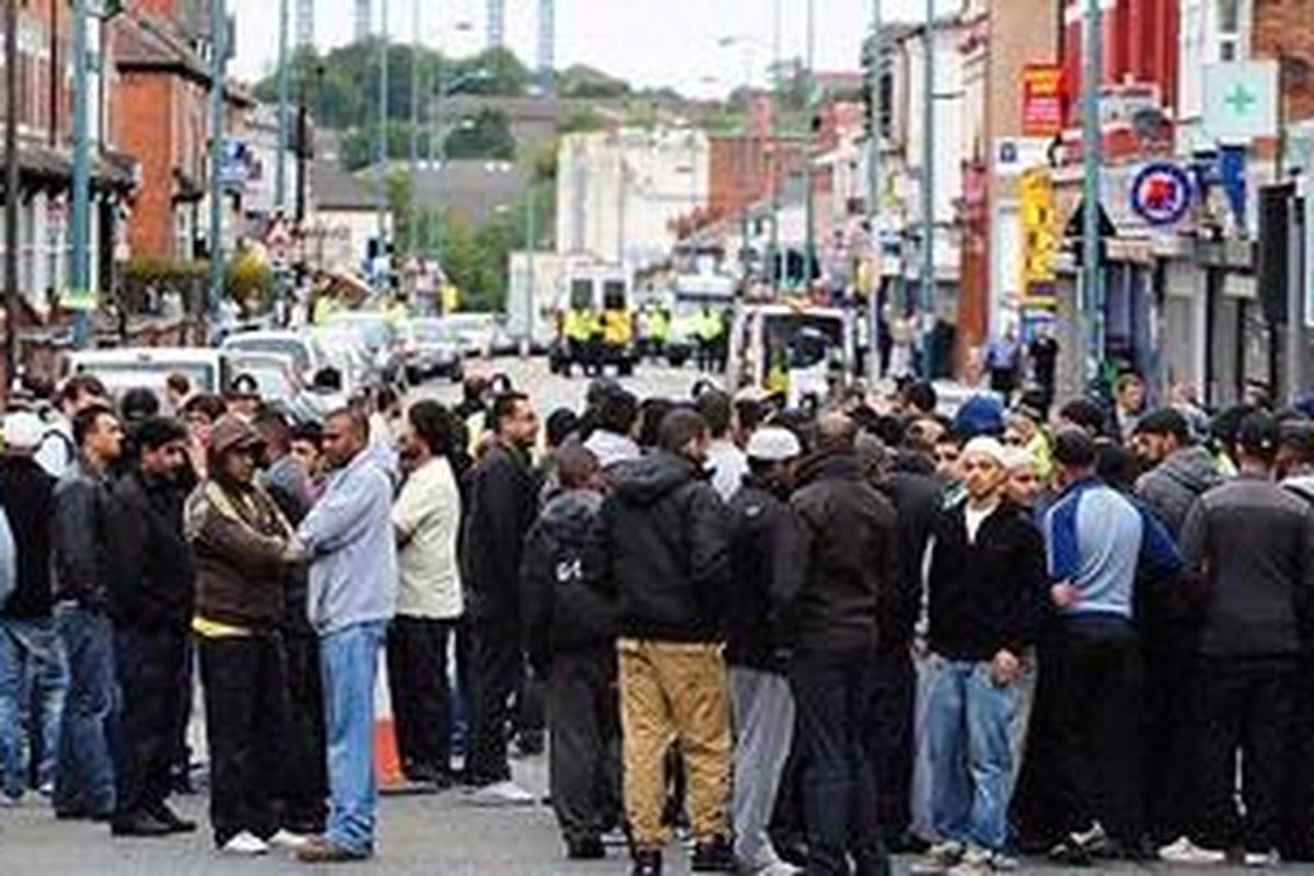 Sekelompok besar orang berkumpul di jalan di mana tiga orang keturunan Asia meninggal di kota Birmingham, Rabu (10/8/2011), dalam lanjutan kerusuhan yang melanda sejumlah kota di Inggris. Ketiga orang itu tewas terlindas mobil saat mereka menjaga kawasan tempat tinggalnya. Kawasan itu berpenduduk warga campuran dari berbagai etnis minoritas. Banyak dari mereka telah menyampaikan belasungkawa terhadap keluarga korban.