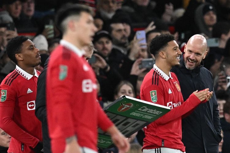 Erik ten Hag saat berbicara dengan Jadon Sancho dalam pertandingan Man United vs Nottingham Forest pada leg kedua semifinal Piala Liga Inggris di Stadion Old Trafford, Kamis (2/2/2023) dini hari WIB. (Foto oleh Paul Ellis/AFP)