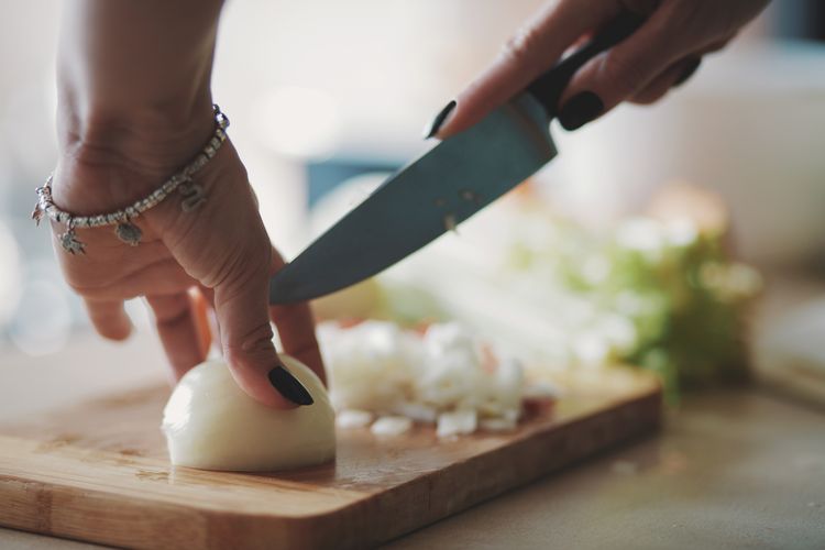 Young woman cutting vegetables in the kitchen