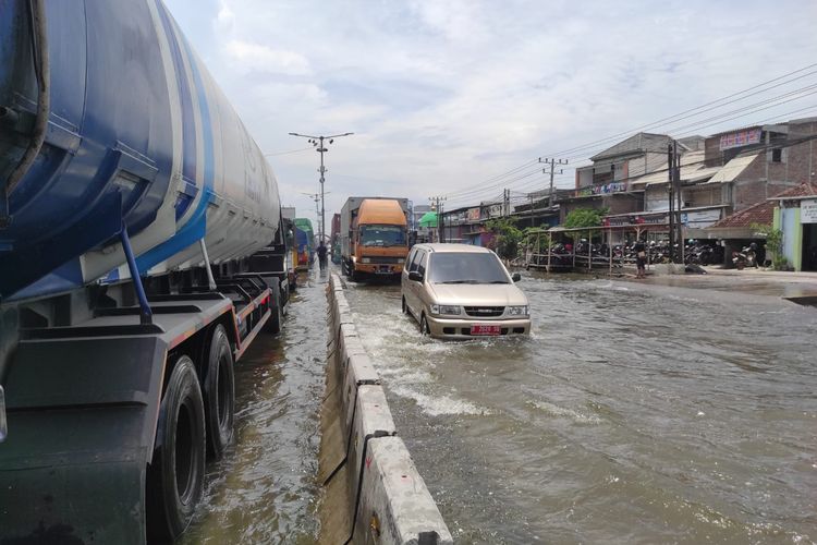 Sejumlah kendaraan melintas Pantura Sayung, Demak dalam kondisi banjir, Rabu (29/10/2025).