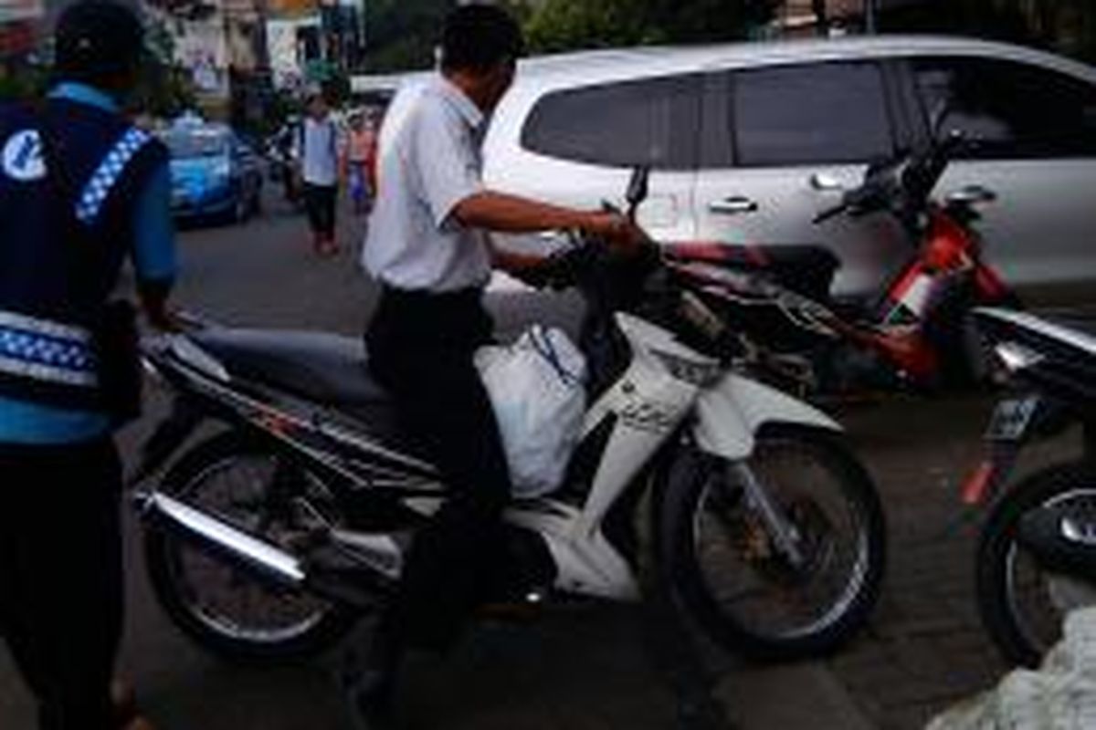 Juru parkir di Jalan Sabang tengah bertugas memandu pengendara motor yang hendak parkir, Selasa (6/1/2015).