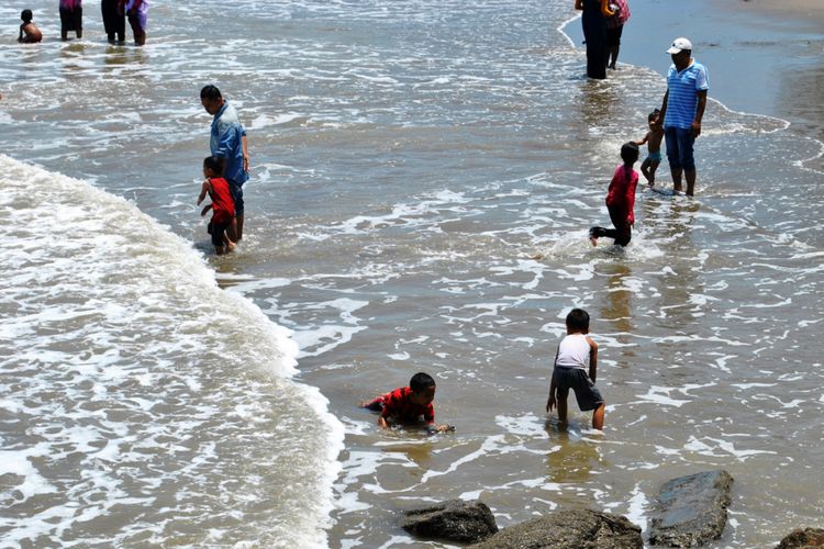 Warga mandi di Pantai Lancok, Desa Lancok, Kecamatan Syamtalira Bayu, Aceh Utara