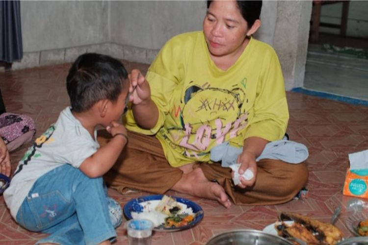 Balita menyantap makanan, hasil panen dari Kebun Gizi dan Budidaya Ikan Lele.