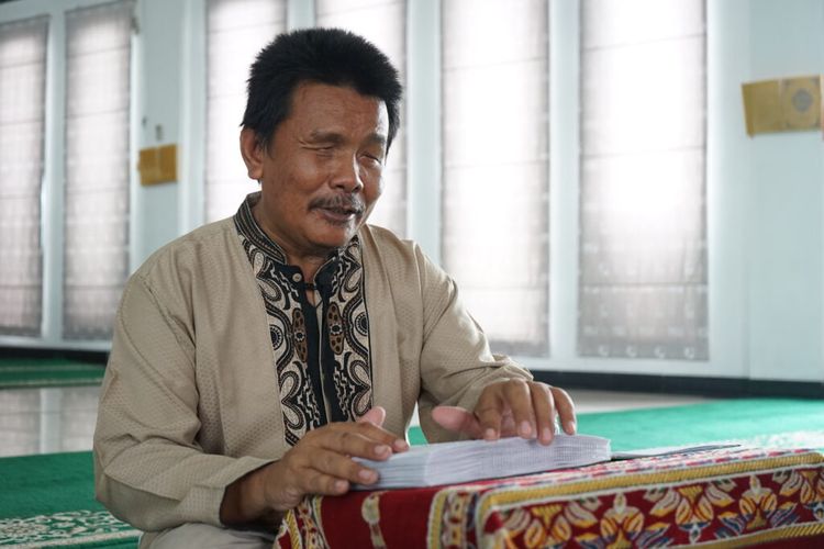 Salah satu tunanetra sedang membaca Al-Quran Braille.