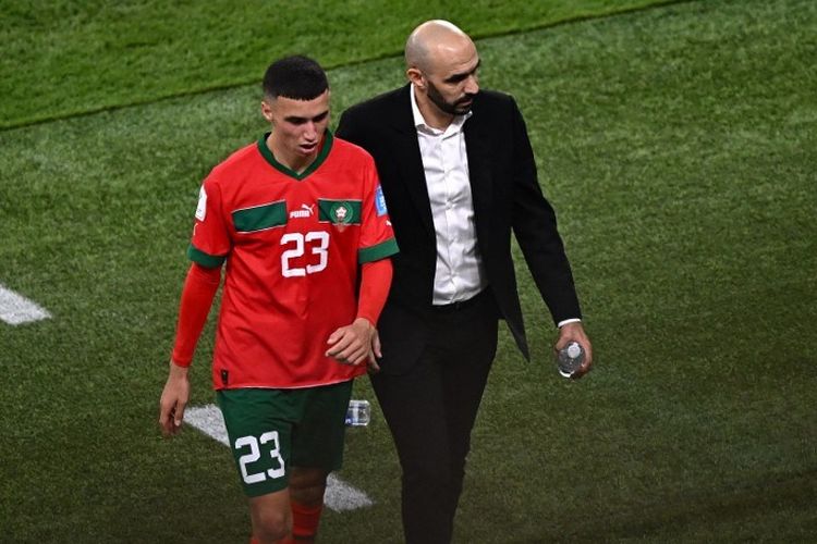 Walid Regragui berjalan lesu bersama Bilal El Khannouss usai laga perebutan peringkat ketiga Piala Dunia 2022 antara Kroasia vs Maroko di Stadion Internasional Khalifa, Qatar, Sabtu (17/12/2022). (Photo by Anne-Christine POUJOULAT / AFP).