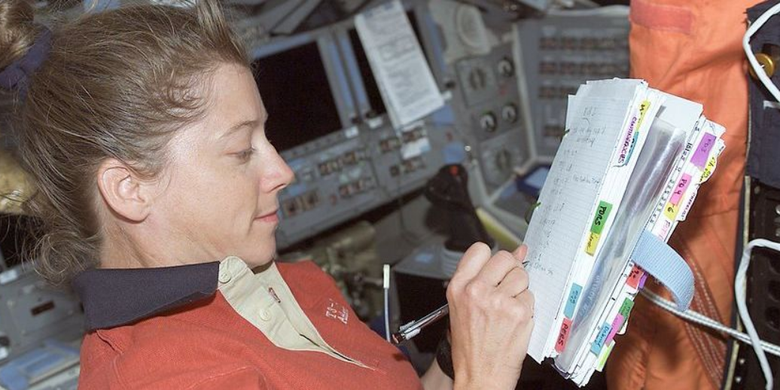 Astronot NASA Pamela Melroy menulis catatan dengan pena luar angkasa. Pensil tidak digunakan dalam aktivitas mencatat oleh para astronot selama menjalankan misi luar angkasa.