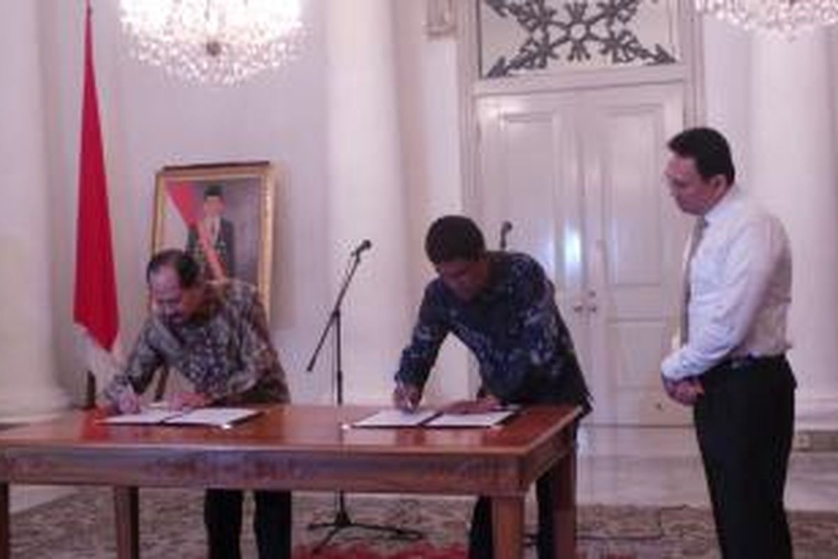 Gubernur DKI Jakarta Basuki Tjahaja Purnama bersama Dirut PT PAM Jaya Erlan Hidayat (pakai batik cokelat) dan Dirut PD PAL Jaya Juniver Pandjaitan (pakai batik biru), saat penandatanganan nota kesepahaman penggabungan PT PAM Jaya dengan PD PAL Jaya, di Balai Kota, Rabu (23/12/2015).