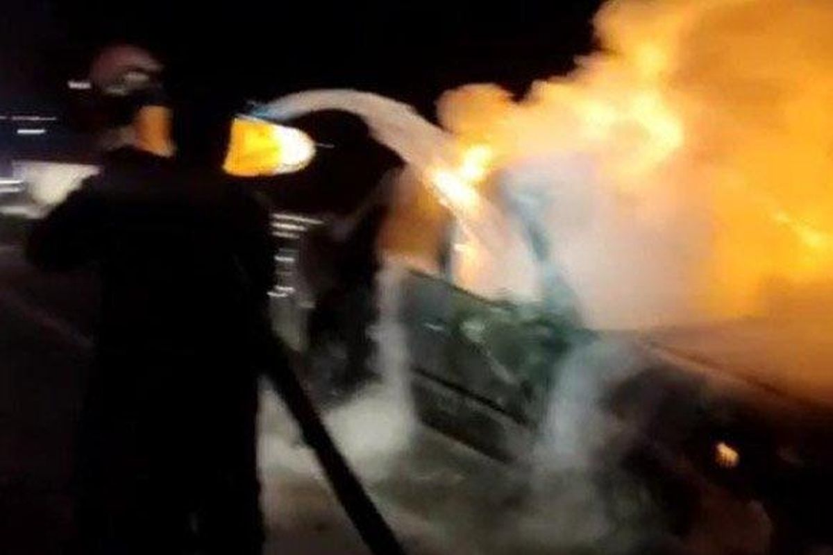 Petugas SAR Kantor Pencarian dan Pertolongan Surabaya memadamkan kebakaran mobil Accord di Tol Jombang-Mojokerto, Jumat (12/4/2024). 
