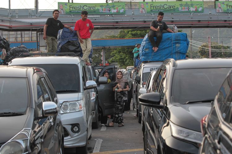 Pemudik keluar dari mobil saat menunggu antrean di area Pelabuhan Merak, Cilegon, Banten, Rabu (19/4/2023). Puncak arus mudik Lebaran 2023 diperkiran terjadi mulai tanggal 18 hingga 21 April.