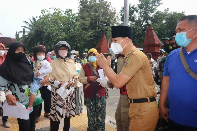 Bupati Trenggalek Mochammad Nur Arifin, menemui antrian warga dalam kegiatan operasi pasar minyak goreng seharga Rp. 13.500 di kawasan alun-alun Trenggalek Jawa Timur, Senin (31/01/2022).