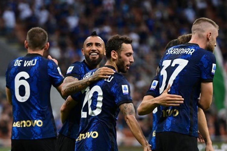 Gelandang Inter Milan, Arturo Vidal, merangkul rekannya, Hakan Calhanoglu, usai menjebol gawang Genoa pada laga Serie A 2021-2022 di Stadion Giuseppe Meazza, 21 Agustus 2021.