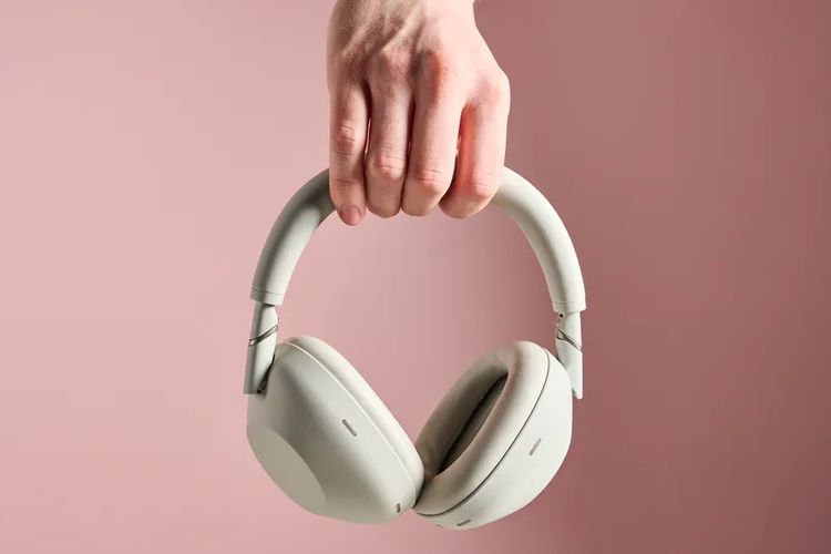 Ilustrasi Sony WH-1000XM6 yang sedang digenggam.