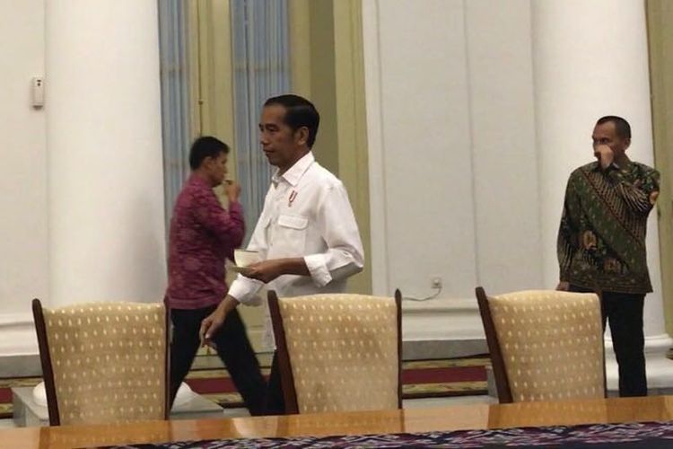 Presiden Joko Widodo memasuki Ruangan Rapat di Istana Presiden Bogor, Minggu (1/10/2017). Sebelumnya, Jokowi sedang mengikuti acara diskusi dengan maniak kopi di teras. Namun hujan turun sehingga acara terpaksa dipindahkan ke dalam.