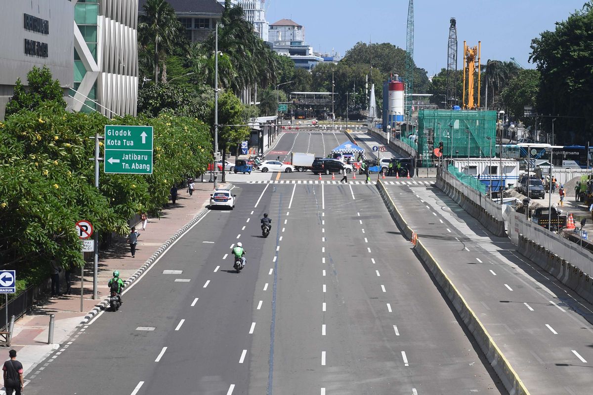 Kendaraan melintasi  jalan yang lengang akibat penyekatan jalan aksi Reuni 212 di Jalan MH Thamrin, Jakarta, Kamis (2/12/2021). Polda Metro Jaya menyebut bahwa kegiatan Reuni 212 tidak bisa digelar lantaran Pemerintah Provinsi DKI Jakarta tak mengeluarkan rekomendasi dan izin penggunaan lokasi reuni.