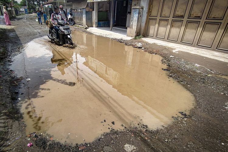 Genangan air di jalan berlubang di Jalan Cisarongge, Desa Mekarmukti, Kecamatan Cihampelas,Bandung Barat, Kamis (18/1/2023).