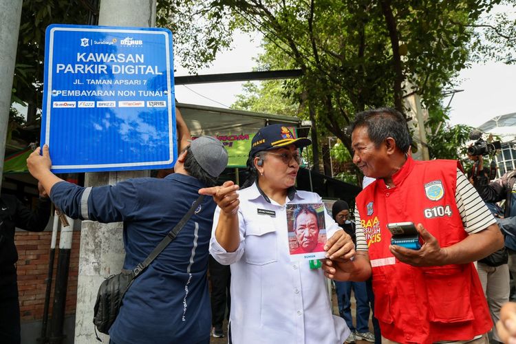 Pemasangan foto juru parkir yang bertanggung jawab atas salah satu titik parkir di Kota Surabaya, Jawa Timur. Juru parkir tersebut juga membawa mesin EDC yang nantinya akan digunakan sebagai gawai untuk memproses pembayaran parkir digital.