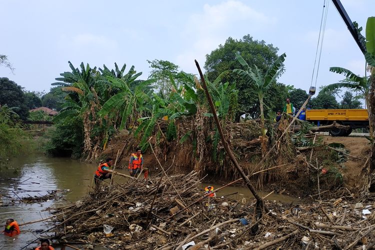 Sejumlah petugas berjibaku mengangkuti sampah bambu yang menumpuk di aliran Kali Cikeas, Jatiasih, Bekasi imbas kiriman dari Bogor sejak Kamis (8/10/2019).