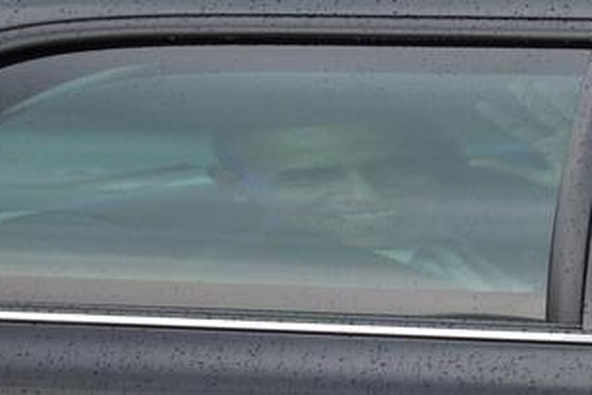 Presiden AS Barack Obama tersenyum dari mobil limousin kepresidenan. 